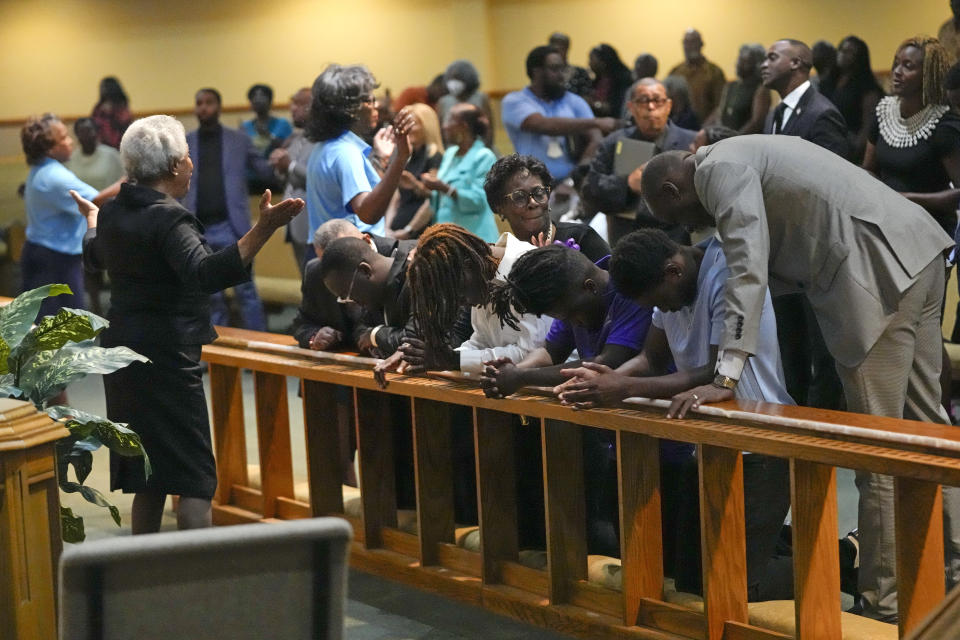 Church members at the St. Paul A.M.E. Church pray with four Edward Waters University students, center, that attended a prayer service for the victims of a mass shooting, Sunday, Aug. 27, 2023, in Jacksonville, Fla. (AP Photo/John Raoux)