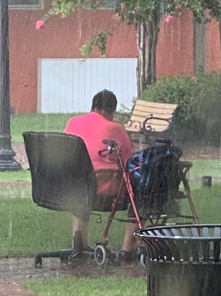 With no shelter, a homeless man sits in the rain in Caldwell Park in Panama City on June 28.