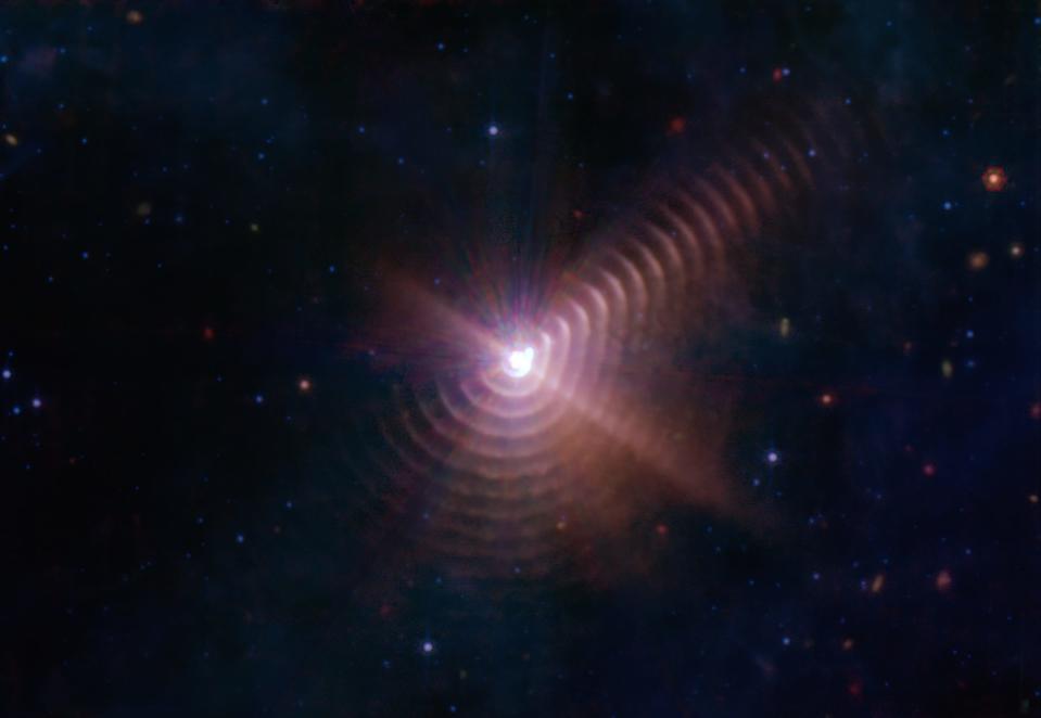 Shells of cosmic dust created by the interaction of binary stars appear like tree rings around Wolf-Rayet 140. The remarkable regularity of the shells’ spacing indicates that they form like clockwork during the stars’ eight-year orbit cycle, when the two members of the binary make their closest approach to one another.