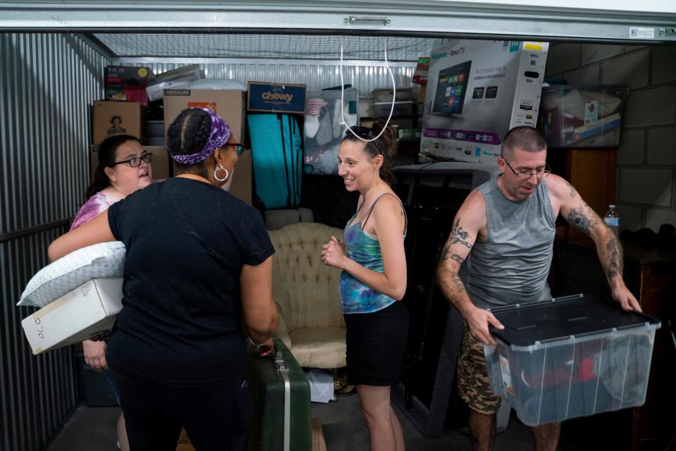 Audrey Sutter, 44, of Wyandotte, left, Tonya Hogan, 50, Christina Hendricks, 34, of Lincoln Park, and Eric Faun, 43, of Wyandotte, transport items from Hogan's Public Storage unit in Dearborn on Thursday, June 29, 2023. "We are trying to help out as much as we can and this is one way we can help," said Sutter, who is a Salvation Army church leader and volunteer.