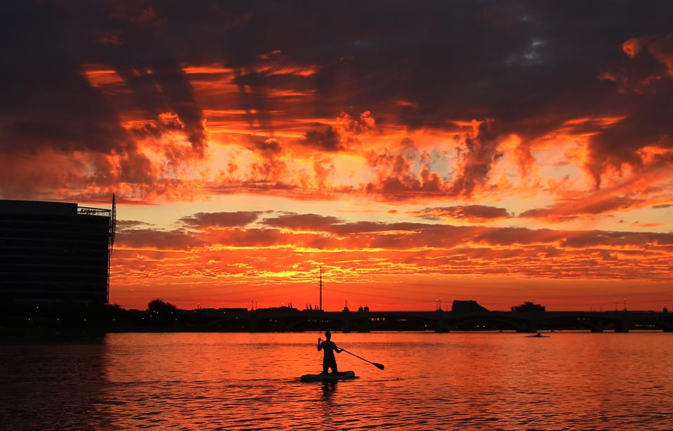 The setting sun illuminates virga falling from clouds over a paddle boarder on Tempe Town Lake on Nov. 2, 2020.