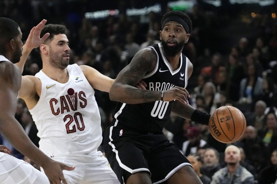 Brooklyn Nets' Royce O'Neale, right, drives around Cleveland Cavaliers' Georges Niang during the NBA basketball game between Brooklyn Nets and Cleveland Cavaliers, at the Accor Arena in Paris, Thursday, Jan. 11, 2024. (AP Photo/Christophe Ena)