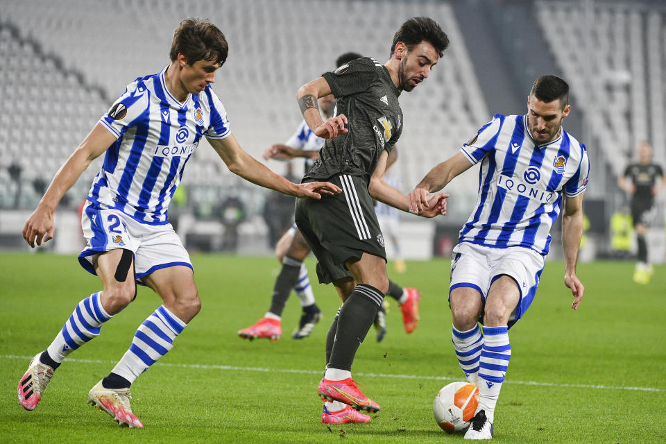 Bruno Fernandes (centro) del Manchester United pugna un balón con Robin Le Normand (izquierda) y Joseba Zaldua de la Real Sociedad en el partido por los dieciseisavos de final de la Liga Europa, en Turín, el jueves 18 de febrero de 2021. (Marco Alpozzi/LaPresse vía AP)