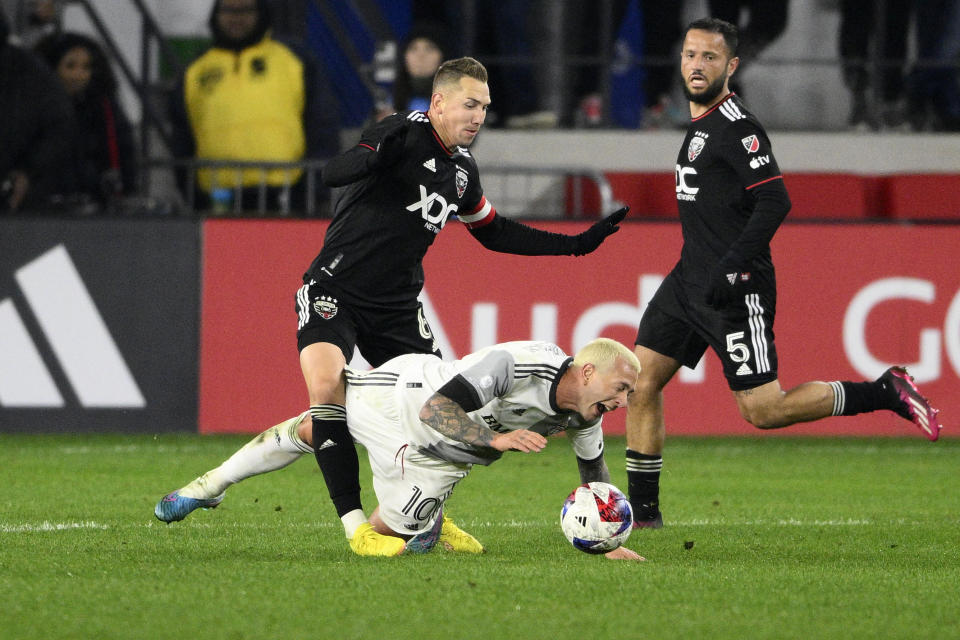 D.C. United midfielder Russell Canouse (6) battles for the ball against Toronto FC midfielder Federico Bernardeschi (10) during the second half of an MLS soccer match, Saturday, Feb. 25, 2023, in Washington. D.C. United defender Mohanad Jeahze (5) watches. (AP Photo/Nick Wass)