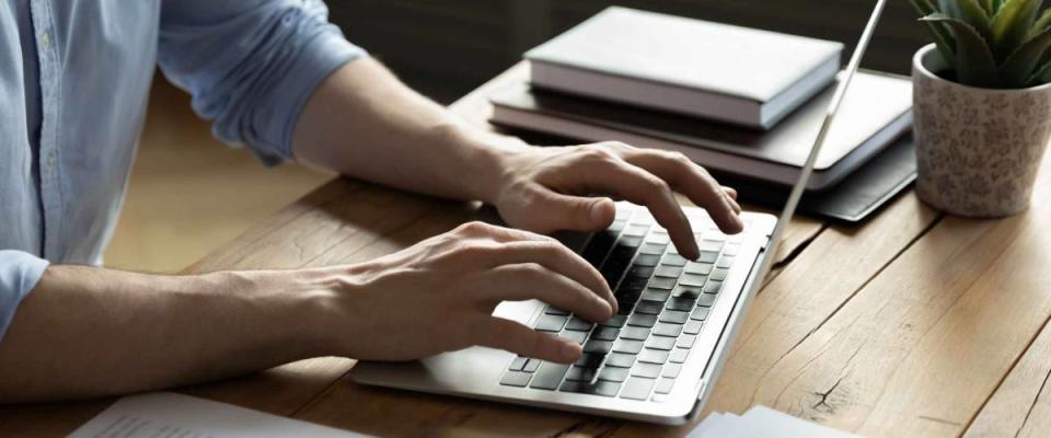 Close up businessman using laptop, typing on keyboard.