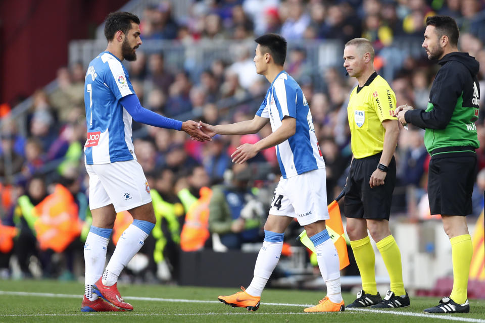 Espanyol's Chinese player Wu Lei, right, shakes hands with Espanyol's Borja Iglesias as he enters as substitute during a Spanish La Liga soccer match between FC Barcelona and Espanyol at the Camp Nou stadium in Barcelona, Spain, Saturday March 30, 2019. (AP Photo/Manu Fernandez)