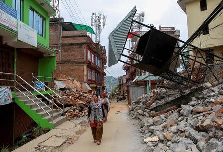 Residents walk past damaged buildings at a village following Saturday's earthquake in Sindhupalchowk, Nepal, April 28, 2015. REUTERS/Danish Siddiqui/Files