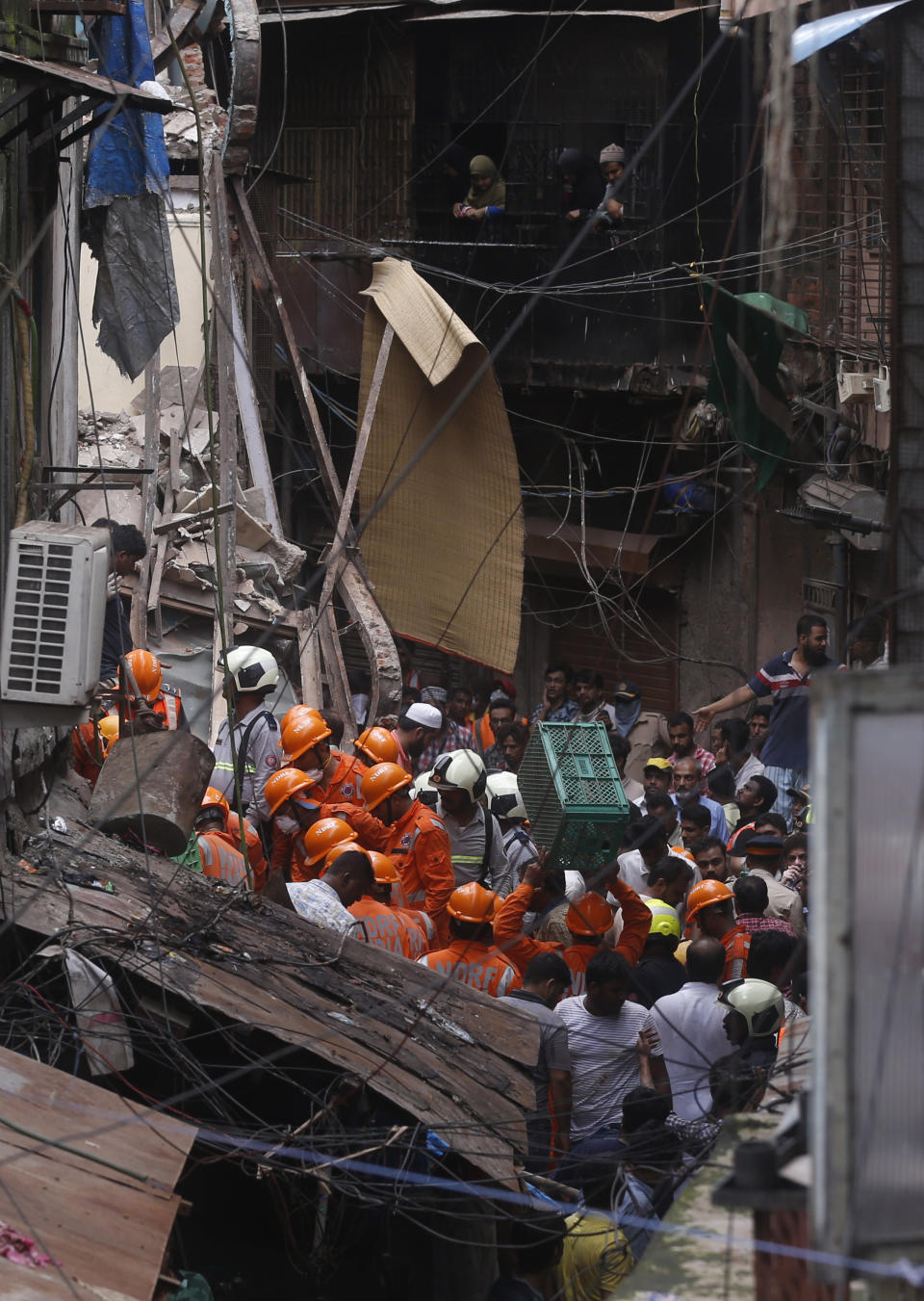 Rescuers work at the site of a building that collapsed in Mumbai, India, Tuesday, July 16, 2019. A four-story residential building collapsed Tuesday in a crowded neighborhood in Mumbai, India's financial and entertainment capital, and several people were feared trapped in the rubble, an official said. (AP Photo/Rafiq Maqbool)