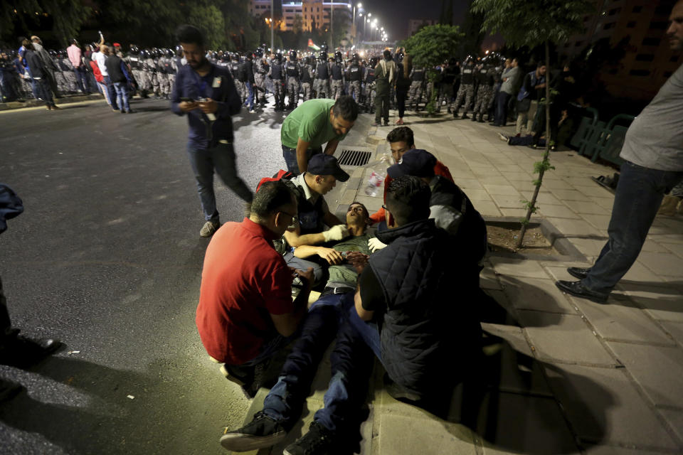 <p>Jordanians tend to an unconscious protester during a demonstration outside the Prime Minister’s office in the capital Amman early Monday, June 4, 2018. (Photo: Raad al-Adayleh/AP) </p>