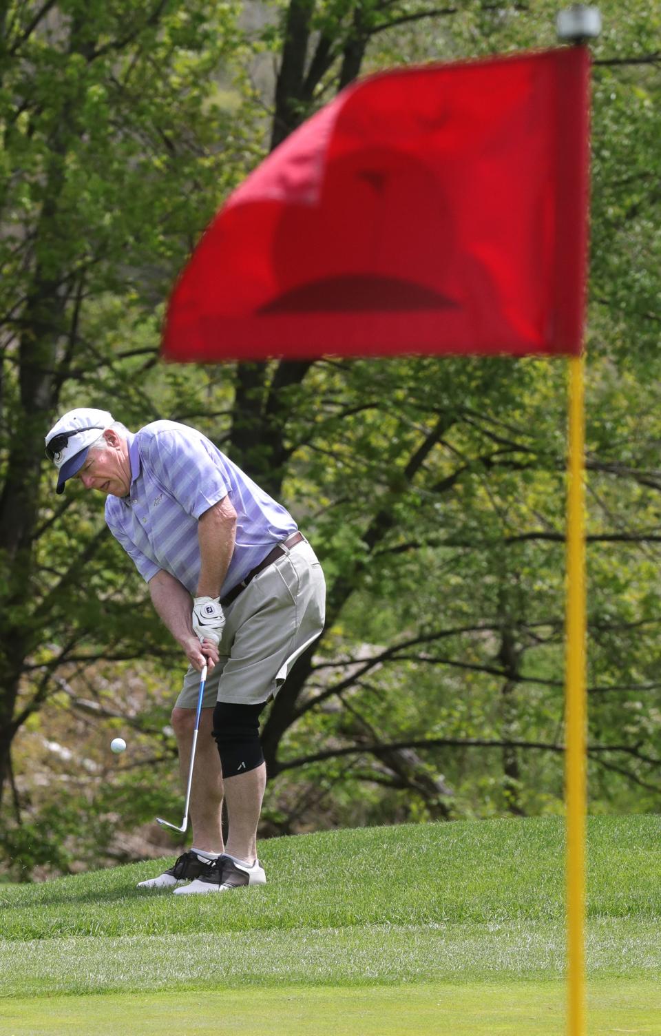 Rance Robenstine hits a chip shot onto the eighth green Tuesday at Sunny Hill Golf Course in Brimfield.