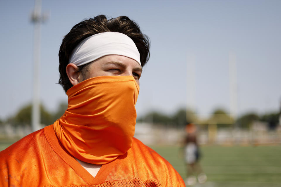 Midland University NAIA college football linebacker Theo Blum wears a face-covering following team practice in Fremont, Neb., Tuesday, Aug. 25, 2020. Midland University is among five small colleges in the state that are pushing forward with plans to play football this fall. The Nebraska Cornhuskers, meanwhile, won't play after Big Ten presidents voted to move back football season until after Jan. 1. Blum said he's grateful he will get to play his senior season when so many other seniors across the country are missing out this fall. (AP Photo/Nati Harnik)
