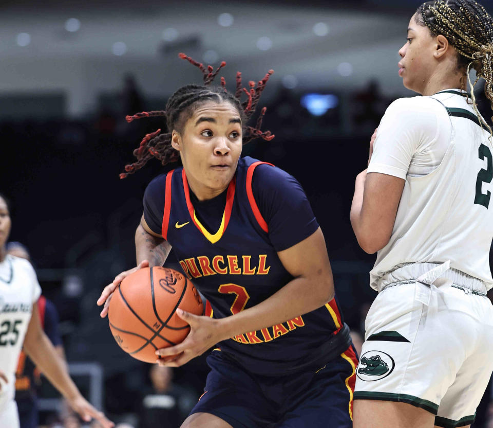 Purcell Marian's Dee Alexander (2) drives to the basket defended by Laurel School forward Saniyah Hall (2) during their state championship game Saturday, March 16, 2024.