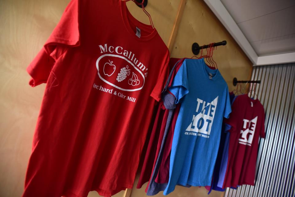 T-shirts are displayed at the The McCallum’s Orchard and Cider Mill store inside the pod at the Lot venue at Fourth and Water streets in downtown Port Huron on Friday, July 8, 2022.