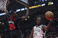 Milwaukee Bucks' Jrue Holiday passes the ball as Toronto Raptors' Chris Boucher defends during the first half of an NBA basketball game Thursday, Dec. 2, 2021, in Toronto. (Chris Young/The Canadian Press via AP)