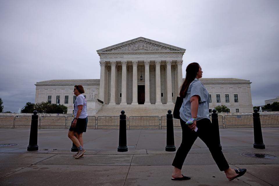 Morning commuters walk by the Supreme Court building, May 24, 2021, in Washington, D.C.