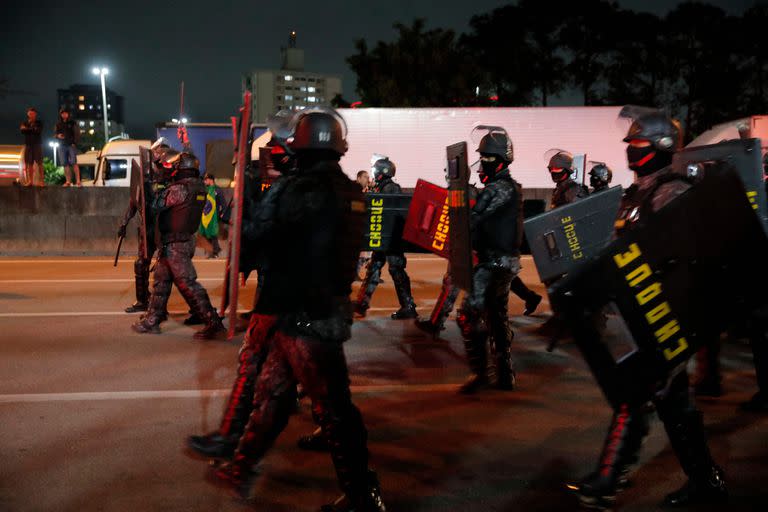 Riot police take position to clear a blockade held by supporters of President Jair Bolsonaro on Castelo Branco highway, on the outskirts of Sao Paulo, Brazil, on November 1, 2022. - Supporters of Brazilian President Jair Bolsonaro blocked major highways for a second day as tensions mounted over his silence after narrowly losing re-election to bitter rival Luiz Inacio Lula da Silva. Federal Highway Police (PRF) on Tuesday reported more than 250 total or partial road blockages in at least 23 states by Bolsonaro supporters, while local media said protests outside the country's main international airport in Sao Paulo delayed passengers and led to several flights being cancelled. (Photo by CAIO GUATELLI / AFP)