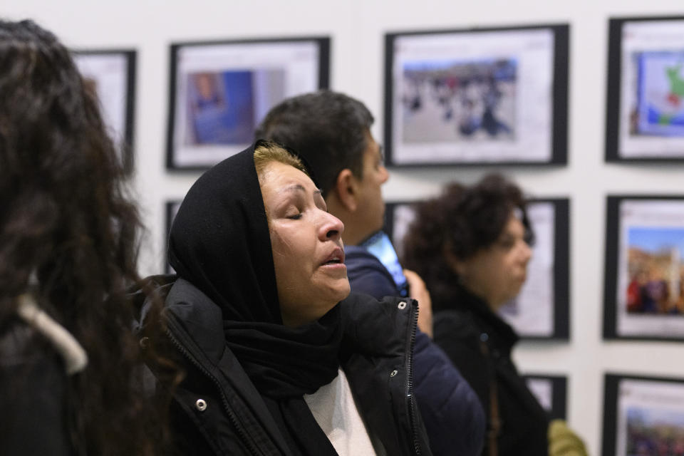 Laila Temori from Afghanistan, who lost her brother, his wife, and their three children in the shipwreck of a migrant boat that capsized in the early morning of Sunday, Feb. 26, 2023, at a short distance from the shore in Steccato di Cutro, near Crotone in the Italian southern tip, killing at least 94 people, visit a photo exhibition about the disaster in Crotone, Saturday, Feb. 24, 2024. Survivors and family members of the victims are converging in the area for a commemoration on Monday, Feb. 26, 2024, on the first anniversary of the disaster. (AP Photo/Valeria Ferraro)