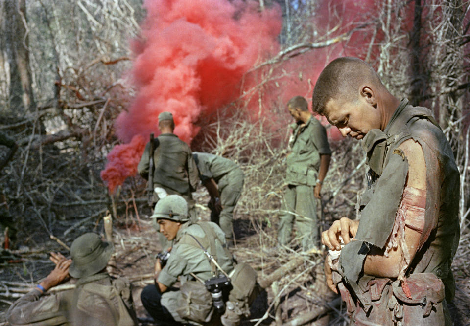 The red smoke from a grenade is a shock of colour in the dull green jungle in Long Khanh Province, March 1966. (AP Photo)