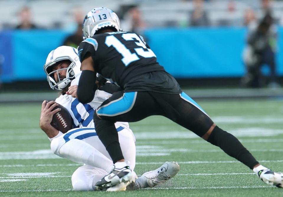 Indianapolis Colts quarterback Gardner Minshew II, left, slides at the conclusion of a run as Carolina Panthers cornerback Troy Hill, right, looks to make the tackle during first-quarter action on Sunday, November 5, 2023 at Bank of America Stadium in Charlotte, NC. Hill was called for a penalty on the play.