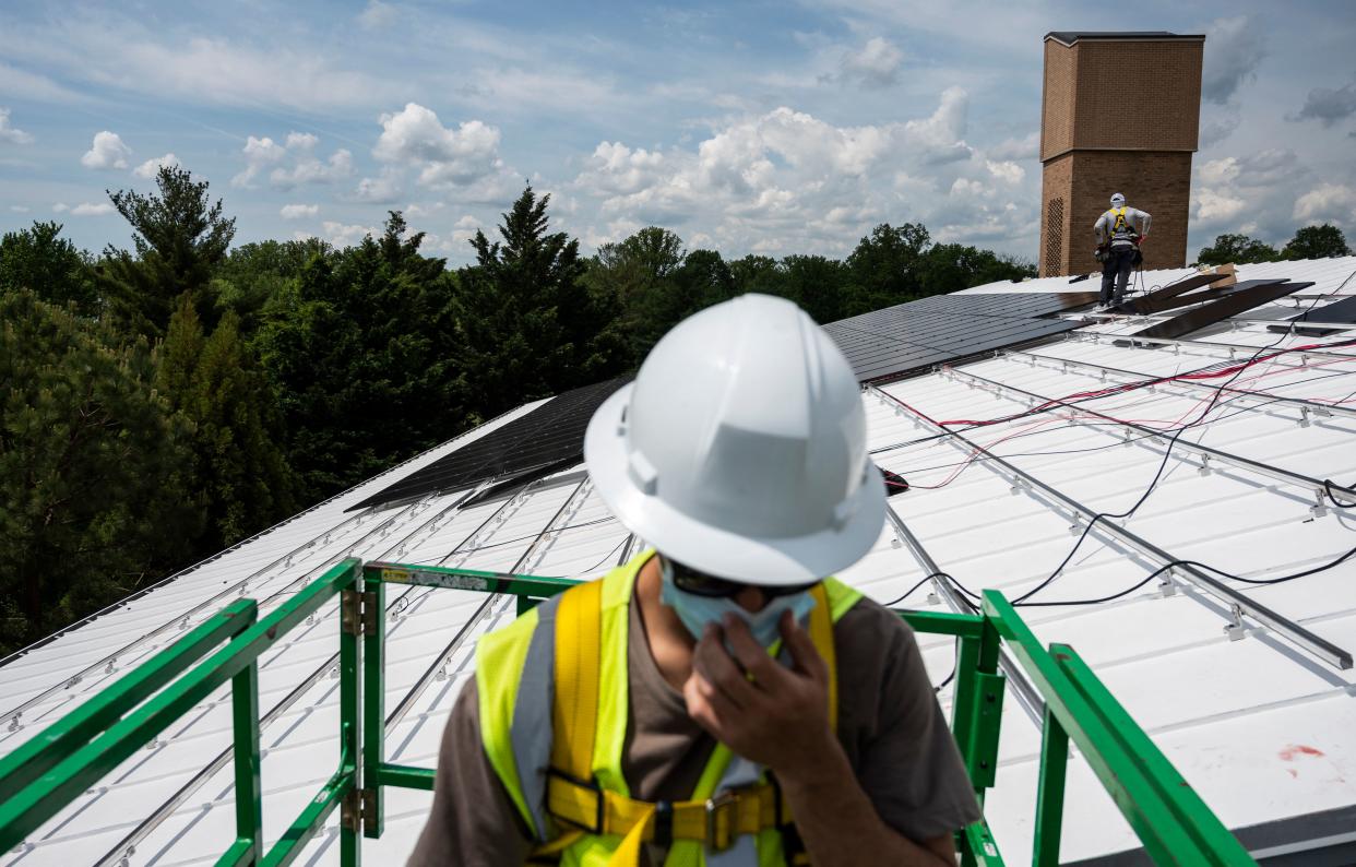 Employees with Ipsun Solar install solar panels on the roof of the Peace Lutheran Church in Alexandria, Virginia on May 17, 2021. (Photo by Andrew CABALLERO-REYNOLDS/AFP)