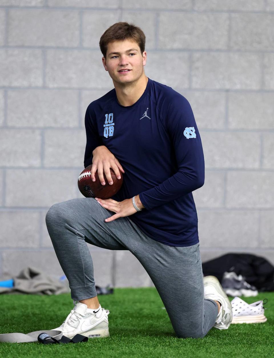 Drake Maye takes a knee along the sideline as he waits for the start of the Carolina Football Pro Day at UNC Chapel Hill’s Koman Indoor Practice Facility on Thursday, March 28, 2024.