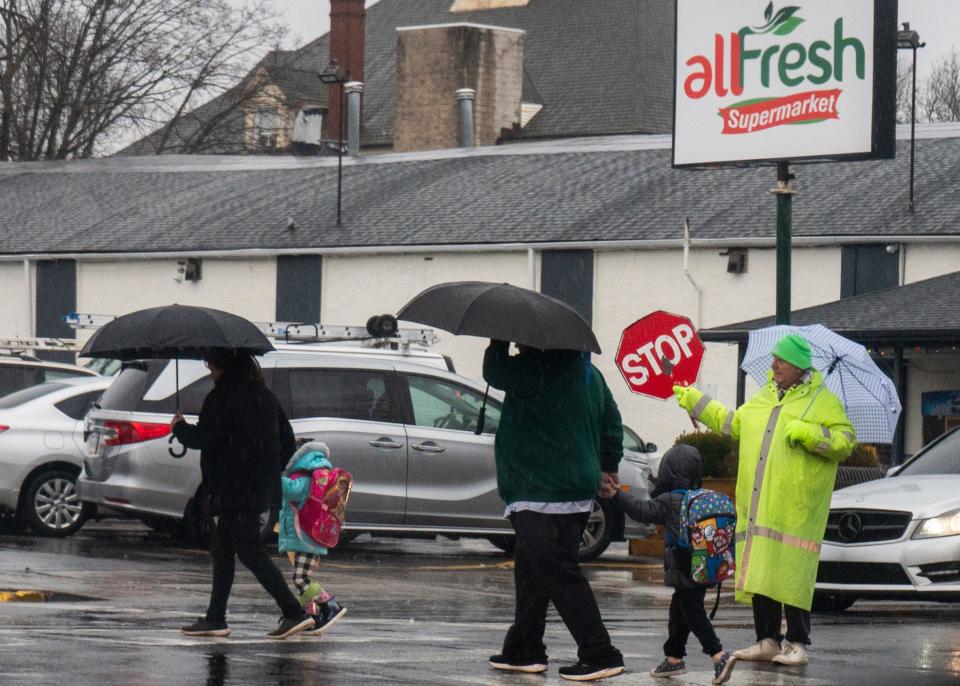 A crossing guard stops traffic so people could run across the street and out of the rain in Bristol Borough on Tuesday, Jan. 9, 2024.

Daniella Heminghaus | Bucks County Courier Times