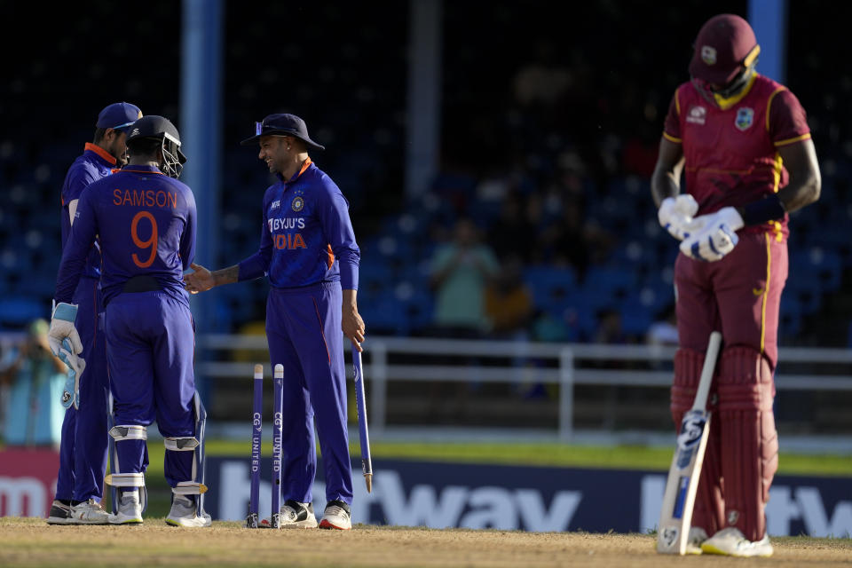 India's captain Shikhar Dhawan, back right, celebrates with teammates as West Indies' Jason Holder, right, takes off his gloves at the end of the third ODI cricket match at Queen's Park Oval in Port of Spain, Trinidad and Tobago, Wednesday, July 27, 2022. India won by 119 runs. (AP Photo/Ricardo Mazalan)