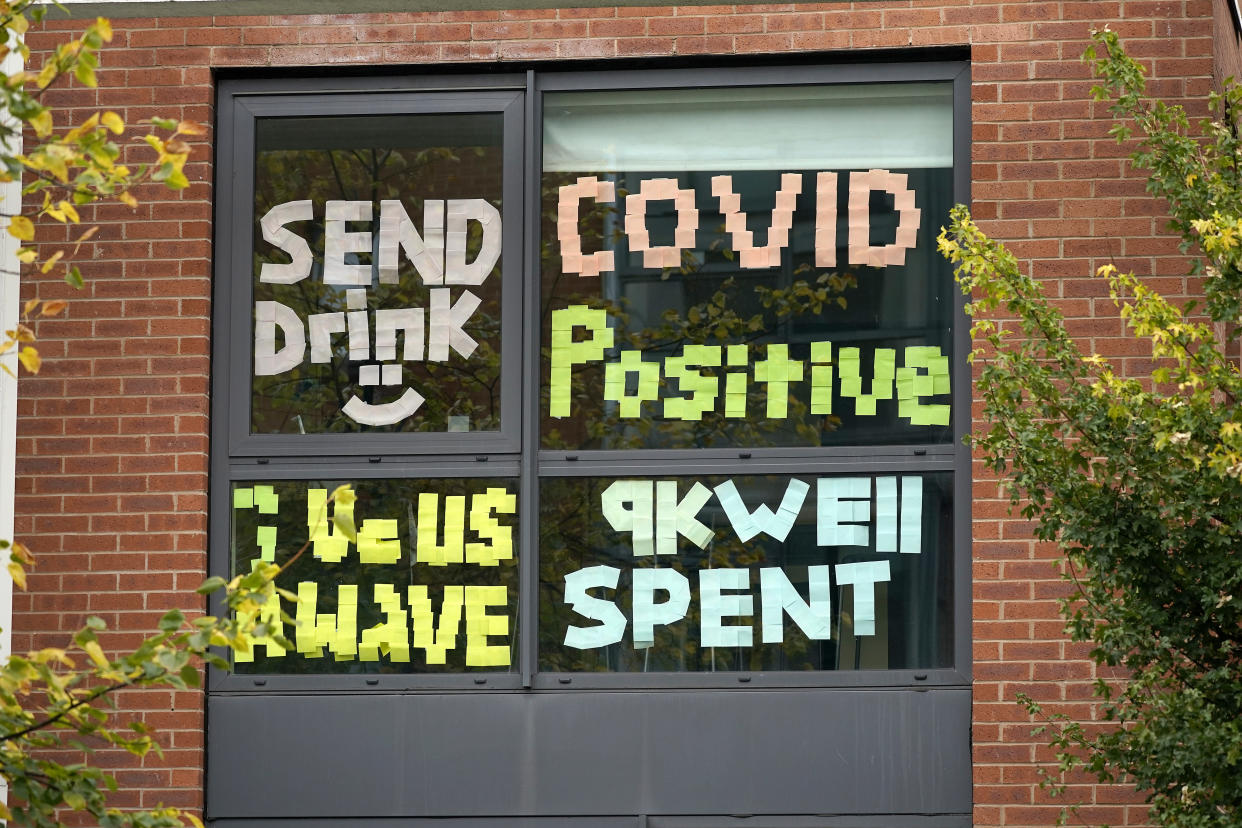 MANCHESTER, ENGLAND - SEPTEMBER 28: Signs made by students are displayed in a window of their locked down accommodation building on September 28, 2020 in Manchester, England. Around 1,700 students across two student housing blocks were told to self-isolate after more than 100 students recently tested positive for Covid-19. The students were told to self-isolate for 14 days even if they were not experiencing symptoms. (Photo by Christopher Furlong/Getty Images)