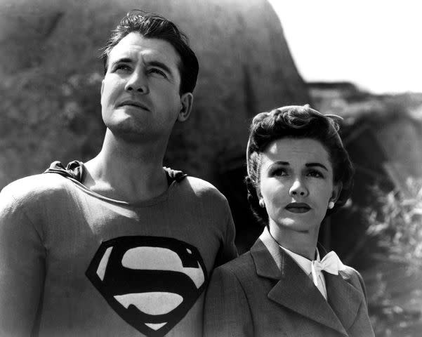 <p>Silver Screen Collection/Getty</p> George Reeves as Superman stands beside Phyllis Coates as Lois Lane in Adventures of Superman in 1952.