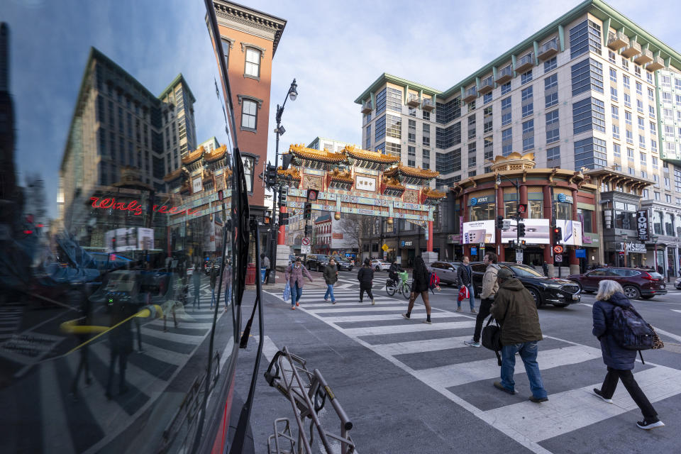 The Friendship Archway is seen to the left of the Capitol One Arena at the busy intersection before an NHL hockey game between the Washington Capitals and the New Jersey Devils, Tuesday, Feb. 20, 2024, in Washington. The proposed move of the Capitals and Wizards sports teams to nearby Virginia has stoked concern in a pair of fragile Washington neighborhoods. Residents and business owners in Chinatown fear that the departure of the teams would devastate the neighborhood around the Capital One Arena. (AP Photo/Alex Brandon)