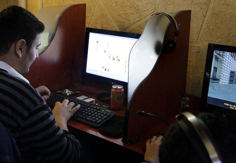 Syrian youths use computers at an internet cafe in Damascus in March 2011. Syrian security forces use tanks, bullets and tear gas against anti-regime protesters by day, but by night they are more stealthy, targeting dissent using the opposition's own weapon, the Internet