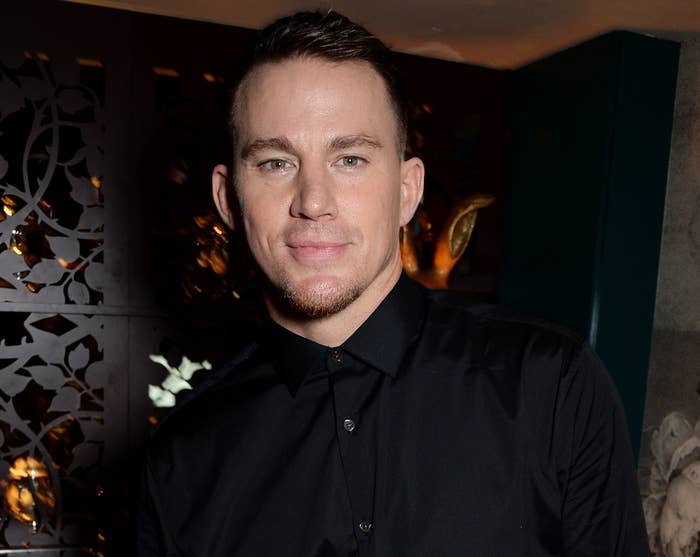 Channing softly smiles while wearing a black button down at an event