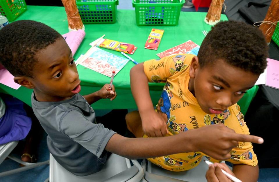 Ezekiel Powell, 7, and Josiah Mooney, 7, Friday at the Manatee County Central Library during the 7th annual Juneteenth Reading Conference.