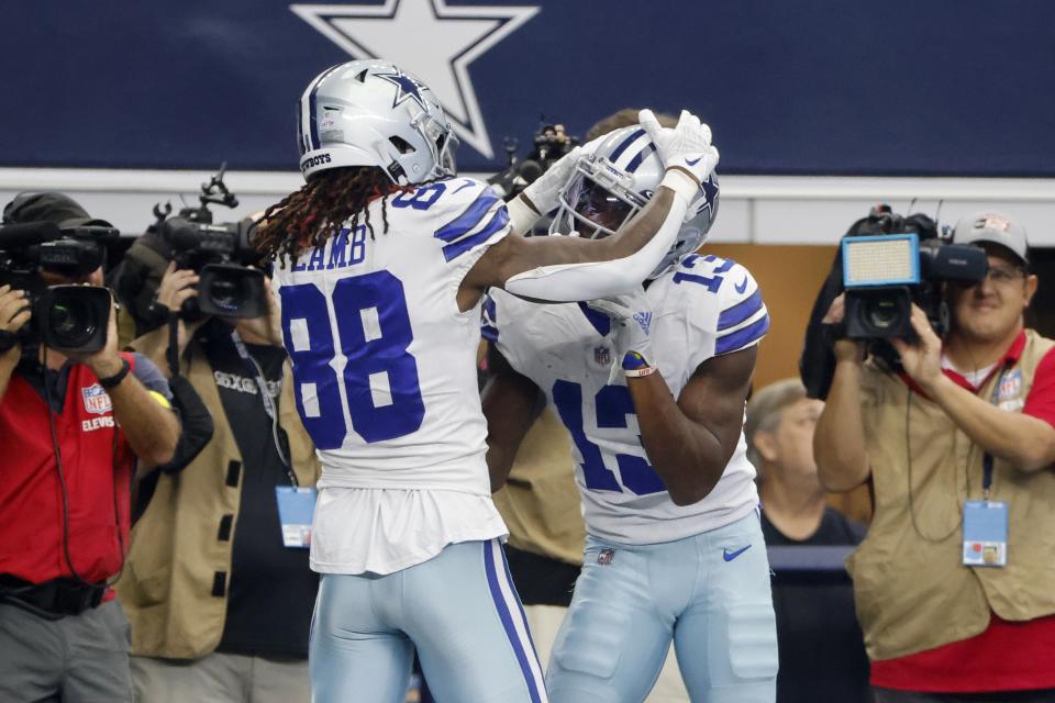 Dallas Cowboys wide receiver CeeDee Lamb (88) celebrates with wide receiver Michael Gallup (13) after Gallup caught a touchdown pass in the first half of a NFL football game against the Washington Commanders in Arlington, Texas, Sunday, Oct. 2, 2022. (AP Photo/Michael Ainsworth)
