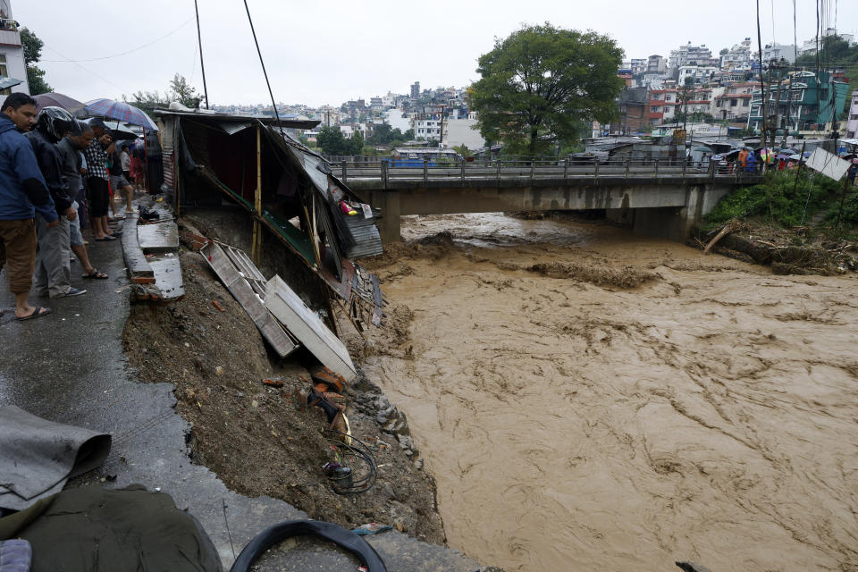 Gente reunida a la orilla del río Bagmati tras fuertes lluvias en Katmandú, el sábado 28 de septiembre de 2024. (AP Foto/Gopen Rai)