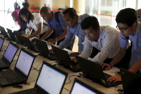 Indonesian youths fill up job application forms on laptops provided by organizers at the Indonesia Techno Career in Jakarta, June 11, 2015. REUTERS/Beawiharta