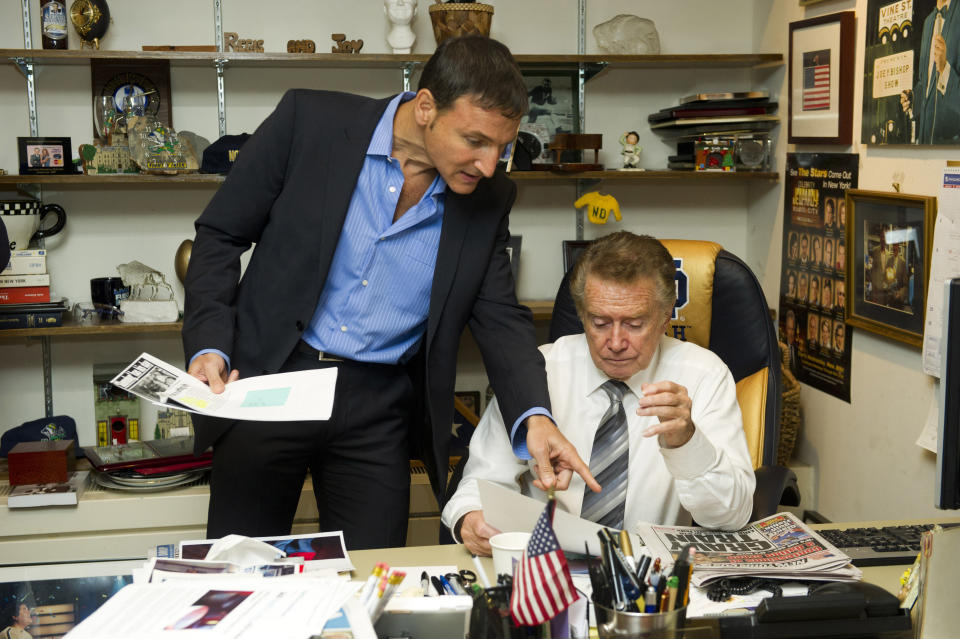 FILE - In this Oct. 28, 2011 file photo, Regis Philbin, right, and producer Michael Gelman go over show prep in Regis's office before a broadcast of "Live! with Regis and Kelly", in New York. Philbin, the genial host who shared his life with television viewers over morning coffee for decades and helped himself and some fans strike it rich with the game show “Who Wants to Be a Millionaire,” has died on Friday, July 24, 2020. (AP Photo/Charles Sykes, File)