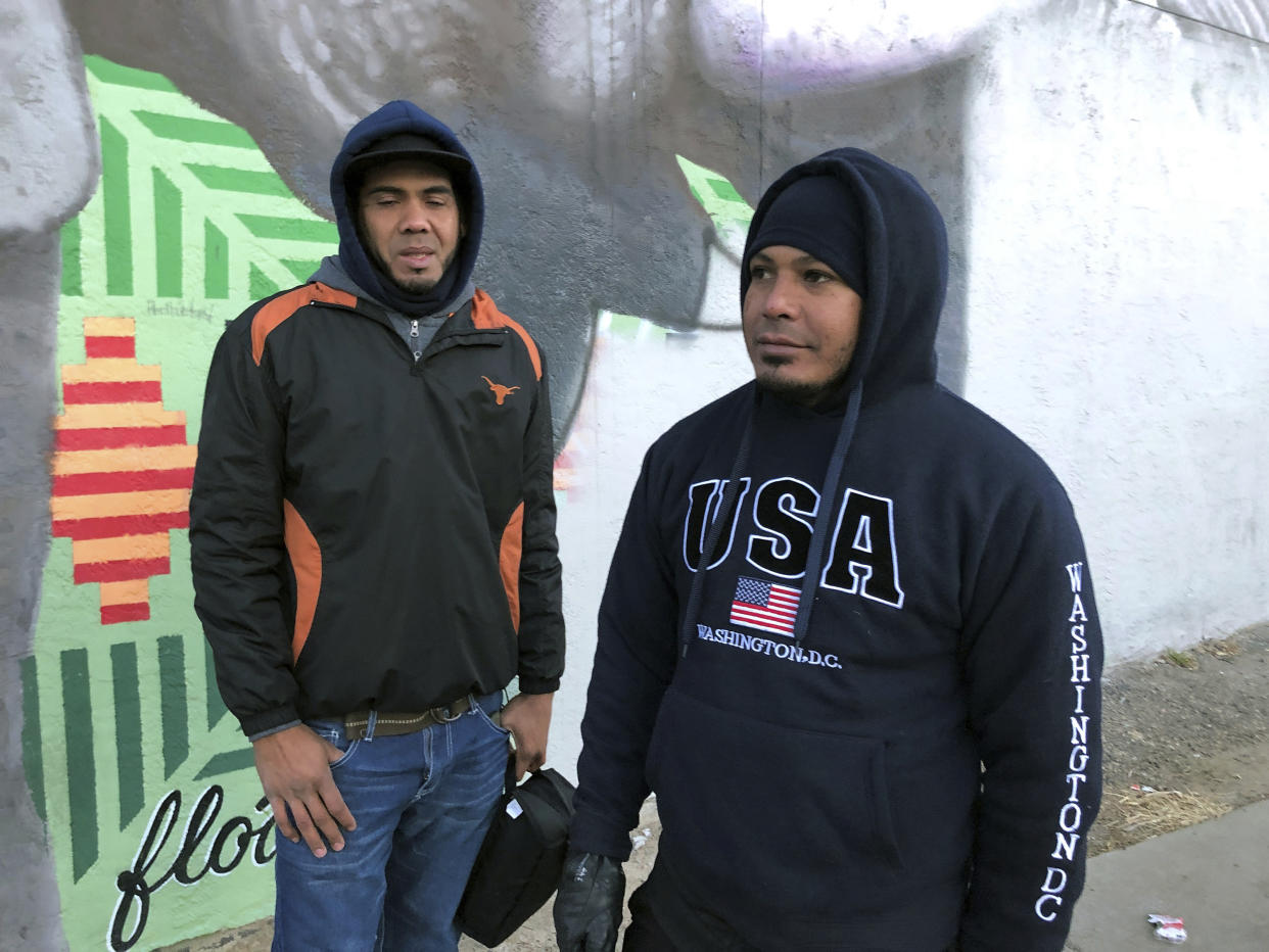 Venezuelan immigrants, Javier Guillen, right, and Abraham Guedez, stand outside a bus station in Denver on Friday, Jan. 6, 2023. They spent three months journeying to the U.S. border and arrived in Denver by bus Friday morning. They are some of nearly 4,000 migrants who came to Denver during the past month that the city is struggling to feed and shelter during a winter cold snap. (AP Photo/Nicholas Riccardi)