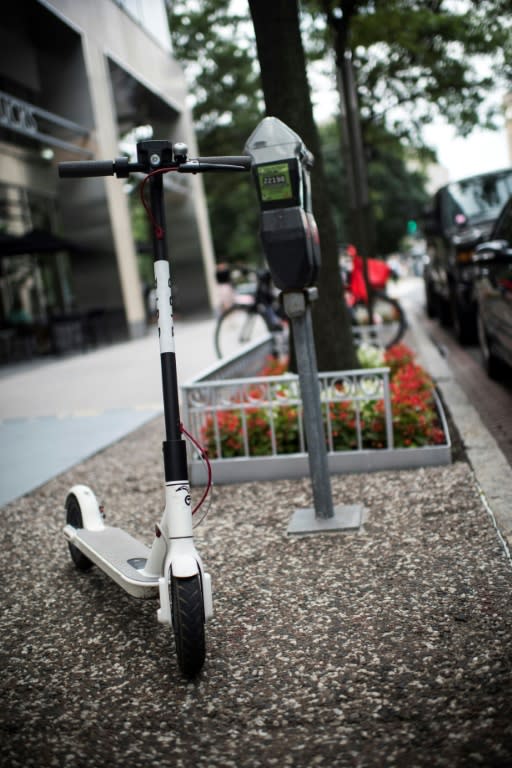 An electric scooter belonging to the startup Bird waits for a rider on a street of downtown Washington, DC