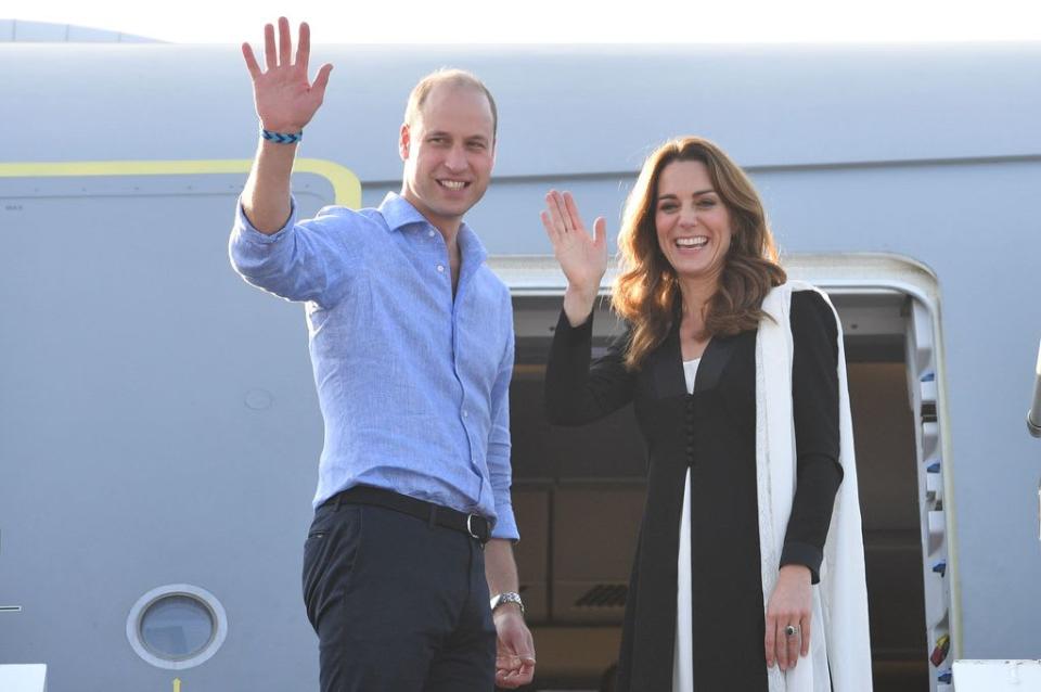 Prince William and Kate Middleton waving before entering an aeroplane