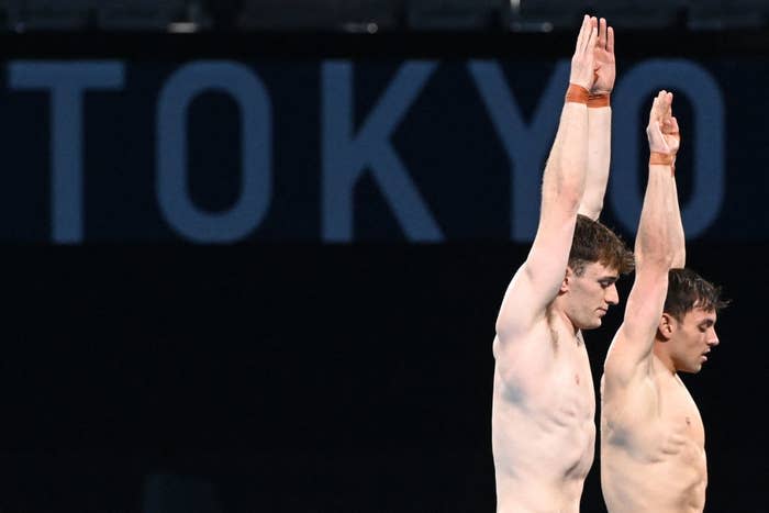 Tom Daley and Matty Lee of Great Britain stand with their arms straight in the air as they prepare to dive