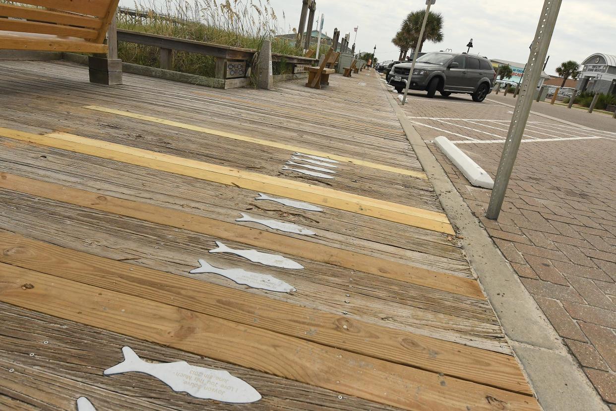 Beachgoers walk along Kure Beach boardwalk Tuesday Aug. 23, 2022. Some Kure Beach residents are "adamantly opposed" to plans to replace the town's boardwalk with a paved path. Town leaders say a paved path could have a longer lifespan and would be lower maintenance but residents say the boardwalk is an iconic part of the beach town. KEN BLEVINS/STARNEWS