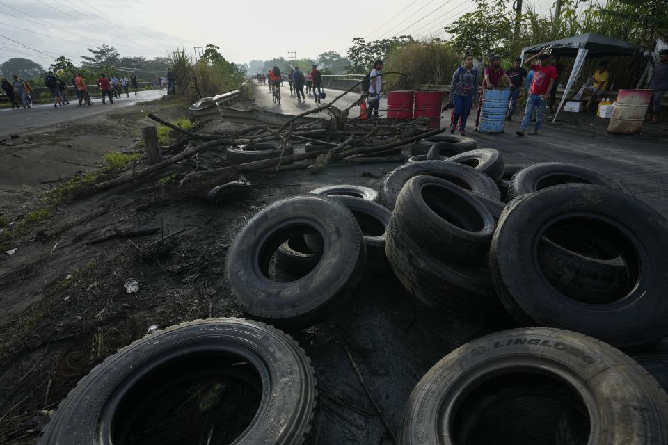 Tires blocking the road force commuters to walk as demonstrators protest inflation, especially surging fuel prices, in Pacora, Panama, early Wednesday, July 20, 2022. (AP Photo/Arnulfo Franco)