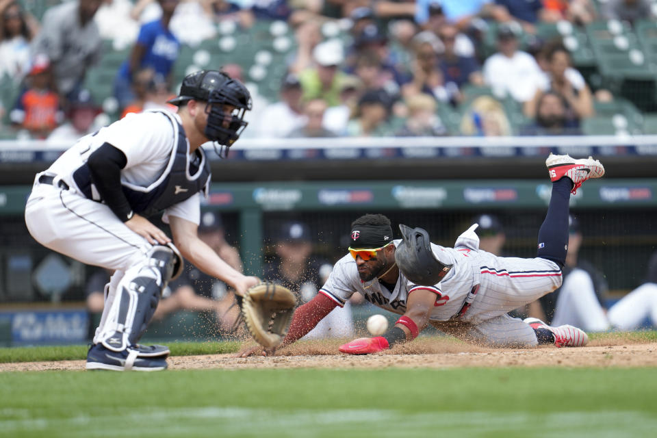Minnesota Twins' Willi Castro slides safely into home plate to score ahead of the throw to Detroit Tigers catcher Jake Rogers, left, in the 10th inning of a baseball game, Sunday, June 25, 2023, in Detroit. (AP Photo/Paul Sancya)