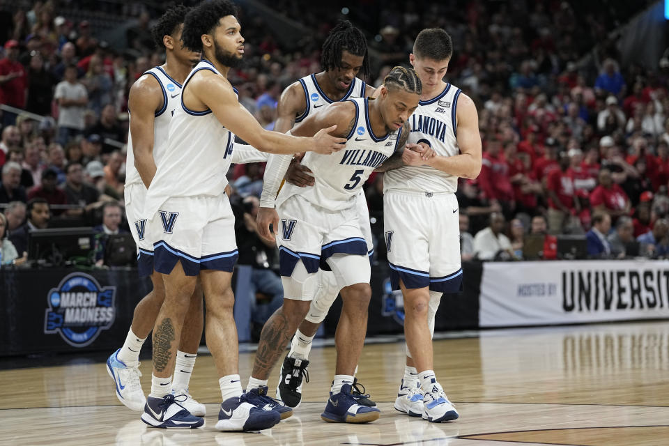 Villanova guard Justin Moore (5) is helped off the floor during the second half of a college basketball game against Houston in the Elite Eight round of the NCAA tournament on Saturday, March 26, 2022, in San Antonio. (AP Photo/David J. Phillip)