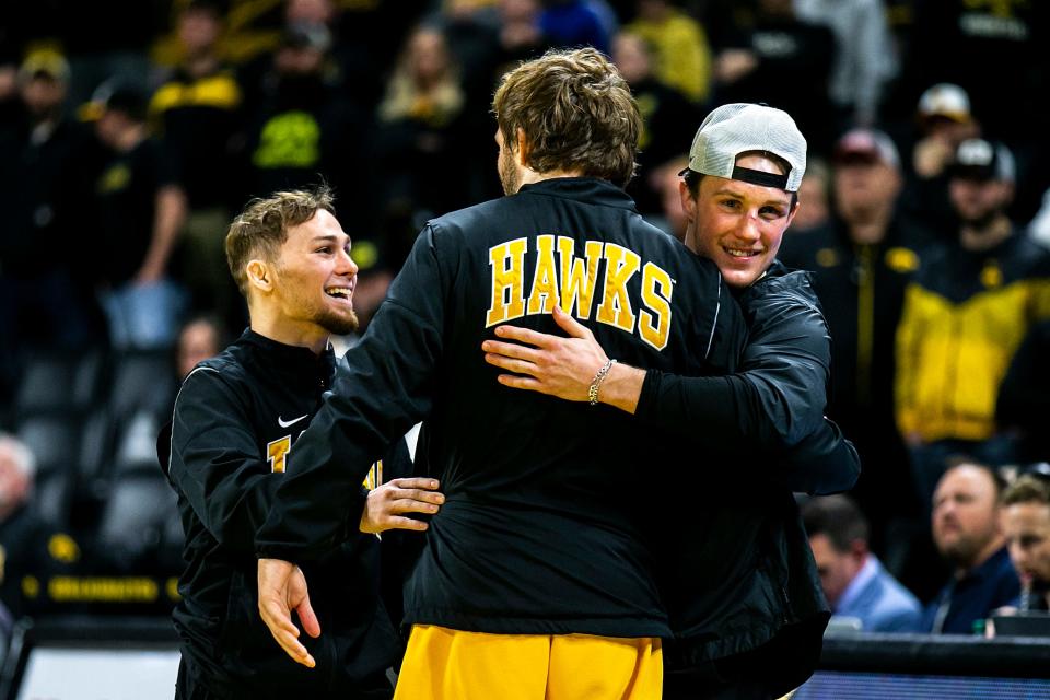 Iowa's Spencer Lee, left, Jacob Warner, center, and Max Murin embrace as they are acknowledged on senior day after a NCAA college men's wrestling dual against Oklahoma State, Sunday, Feb. 19, 2023, at Carver-Hawkeye Arena in Iowa City, Iowa.