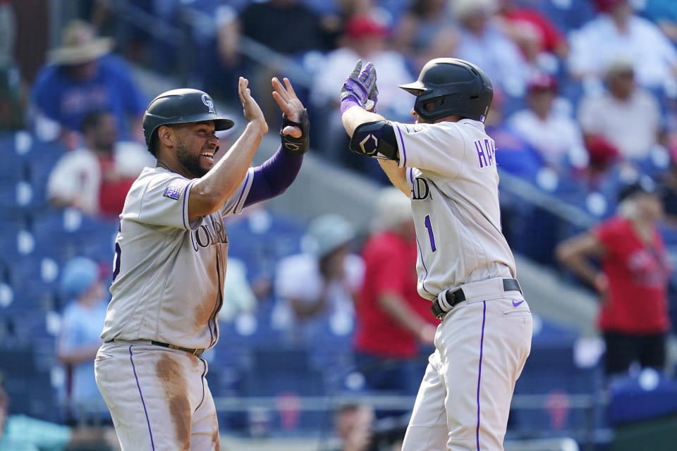 Colorado Rockies' Elias Diaz, left, and Garrett Hampson celebrate after Hampson hit a two-run-home run against Philadelphia Phillies pitcher Hector Neris during the seventh inning of a baseball game, Sunday, Sept. 12, 2021, in Philadelphia. (AP Photo/Matt Slocum)