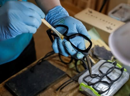 A worker makes eco-friendly sunglass frames from coffee waste in workshop near Kiev