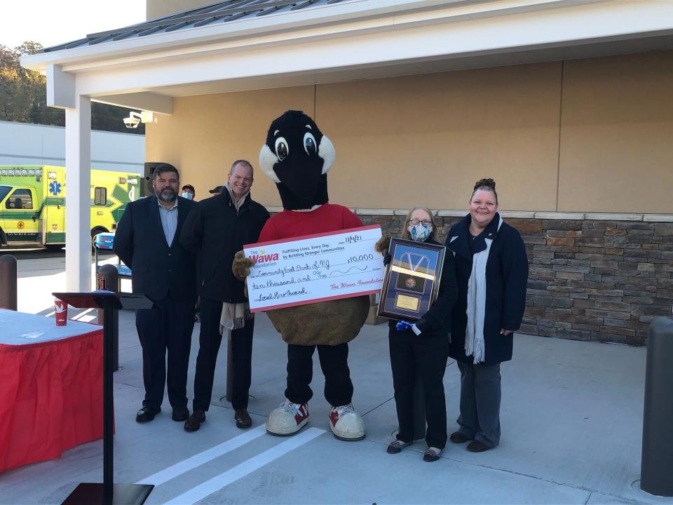 From left, Wawa area manager Bill Ott, director of store operations Jason Read, mascot "Wally," Wawa Foundation Hero Award recipient Mary O'Connell and new store general manager Alicia Harenza display a check for $10,000 to the Community FoodBank of New Jersey at the grand opening of the newest Wawa convenience store on Route 15 South in Jefferson Thursday, Nov. 4, 2021.