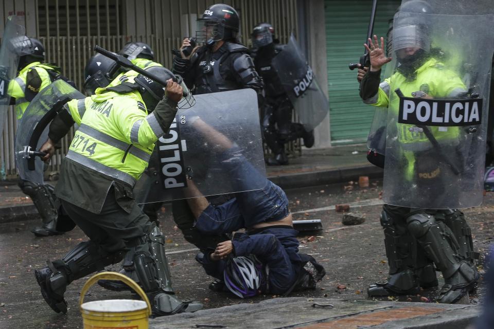 A police officer bears down on an anti-government protester during clashes in Bogota, Colombia, Wednesday, June 9, 2021. The protests have been triggered by proposed tax increases on public services, fuel, wages and pensions. (AP Photo/Ivan Valencia)